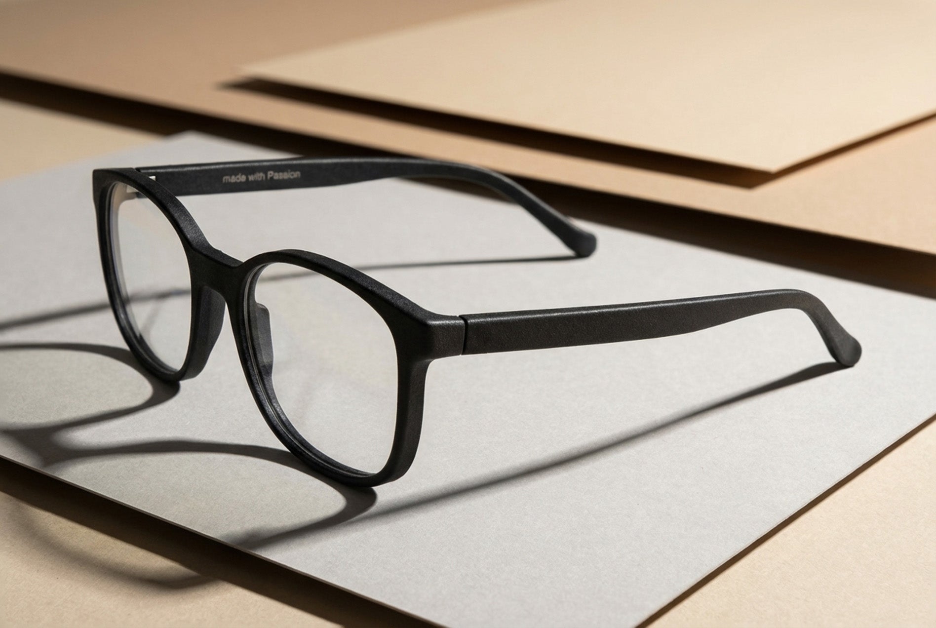 minimal eyewear product photography showing modern optical frame prototype on layered material boards
