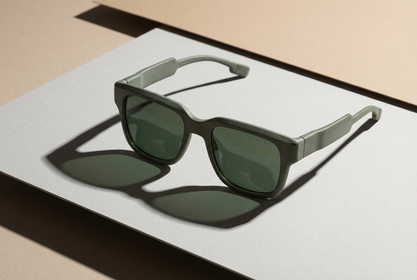 Transparente Sonnenbrille mit grün getönten Gläsern auf minimalistischer Studiofläche