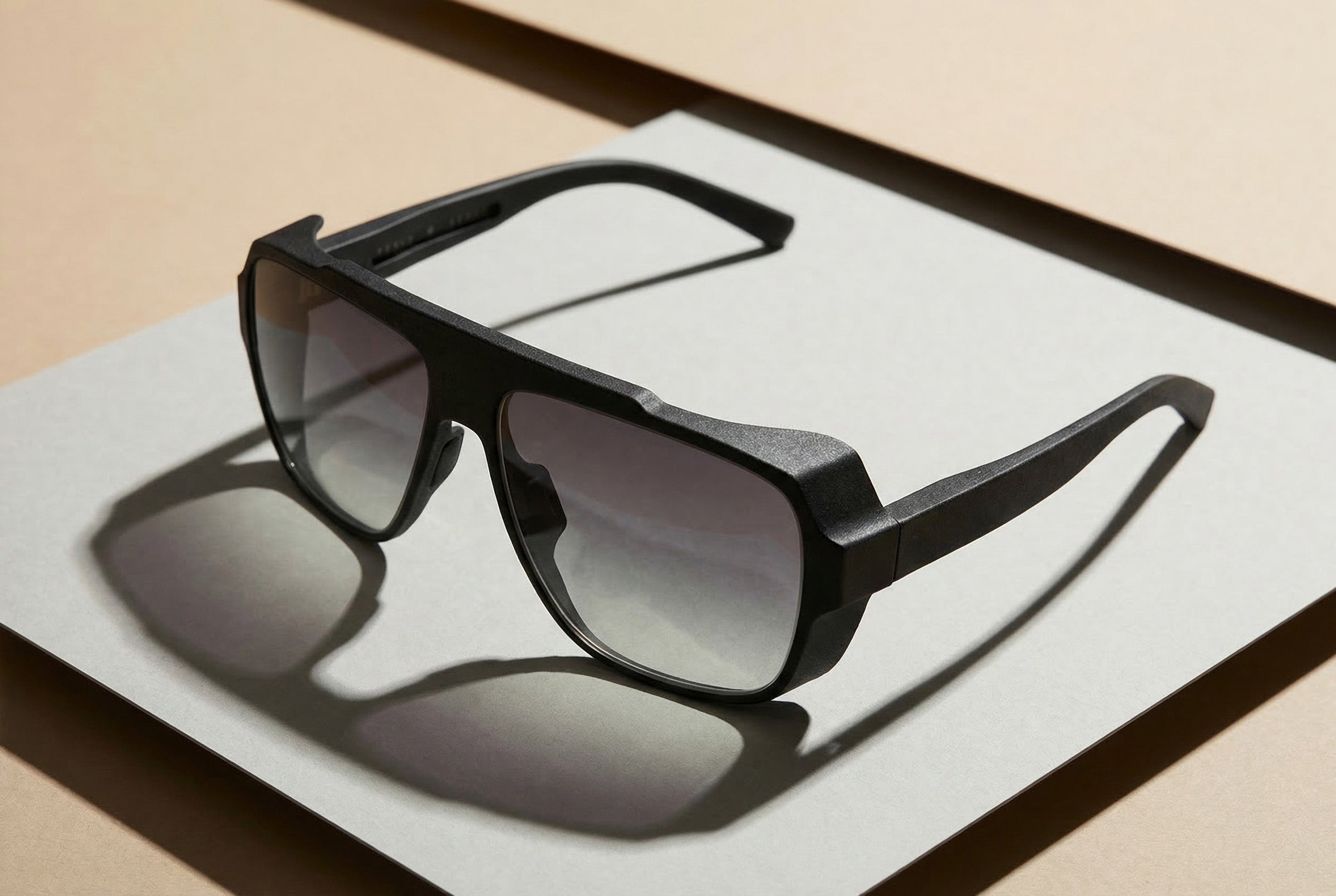 Schwarze Sonnenbrille mit dunklen Gläsern, klare Produktinszenierung auf neutralem Hintergrund
