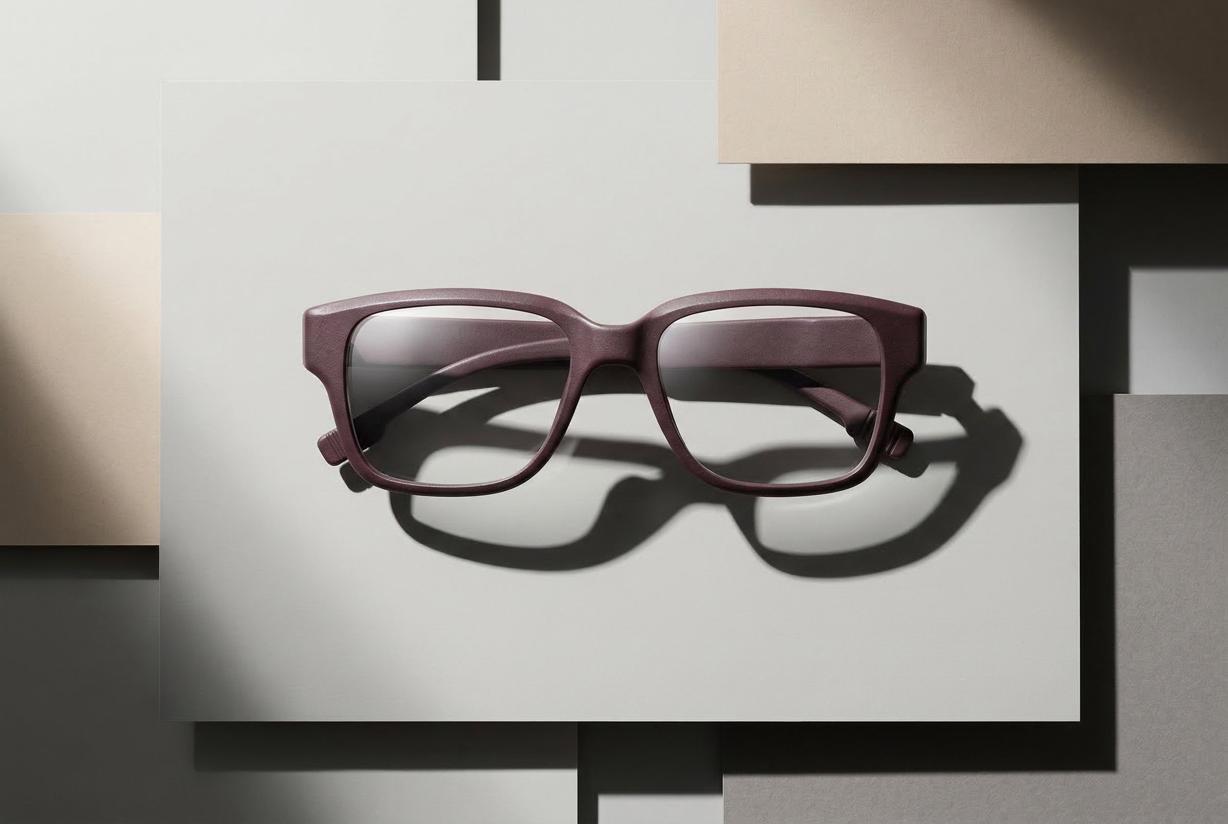Zwei übereinanderliegende 3D-gedruckte Brillen als grafische Komposition auf geometrischem Studio-Setup